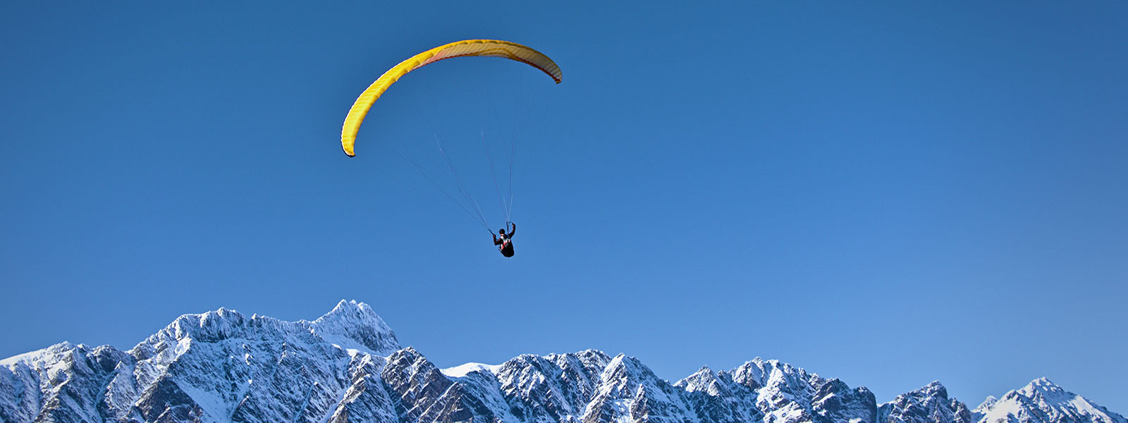 Paraglider above Remarkables range, Queenstown, Otago, New Zealand
